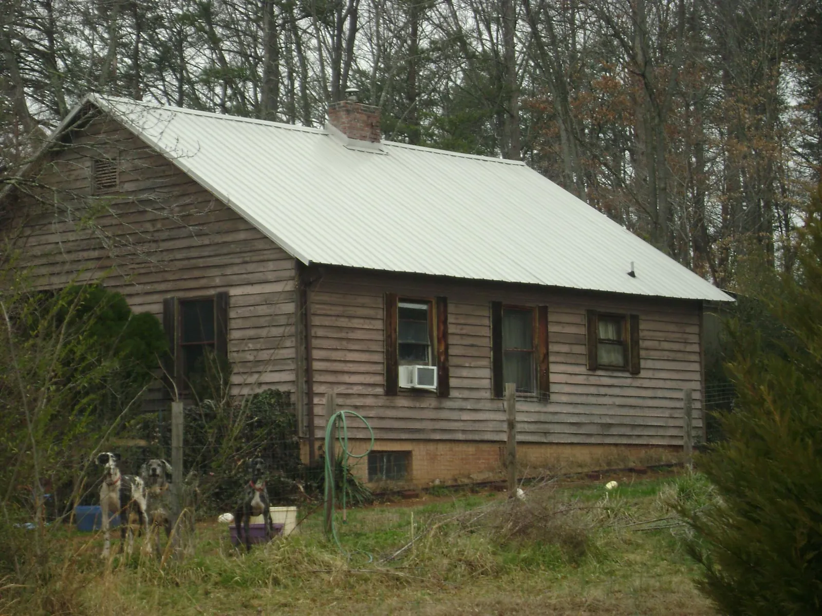 White metal roof on an old wood sided farmhouse, from a Metal Roof Installation job in Walnut